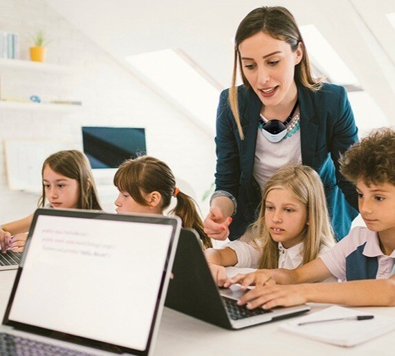 Teacher with kids on laptop copy-1-2 Teacher with kids on laptop copy-1-2